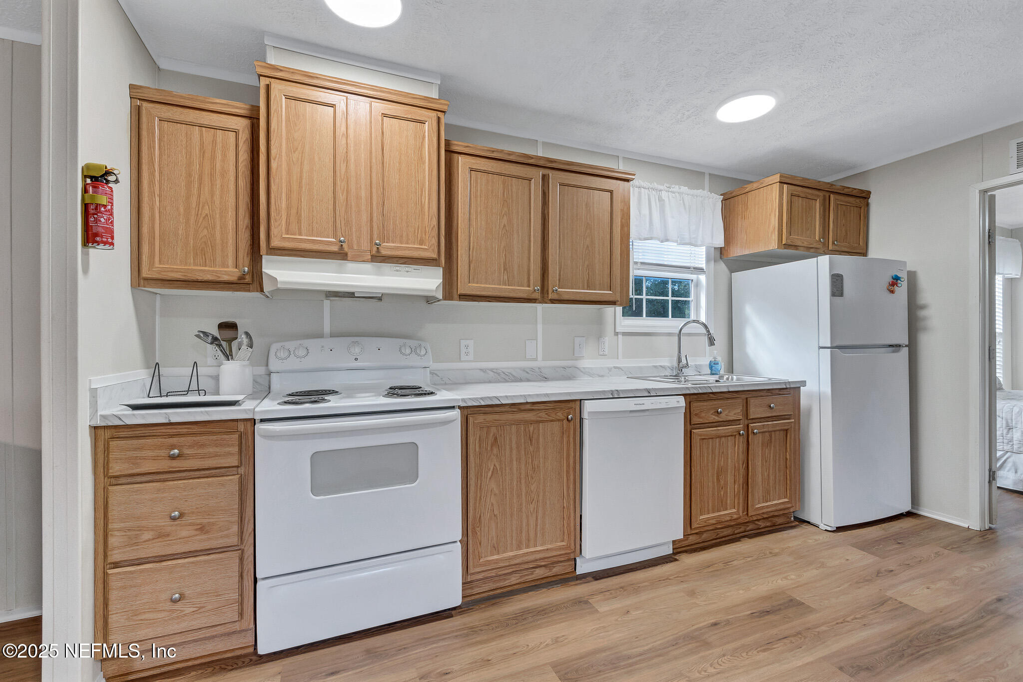 86446 Peeples Road Yulee, FL 32097 - Photo 28 of 42 a kitchen with white cabinets and white appliances