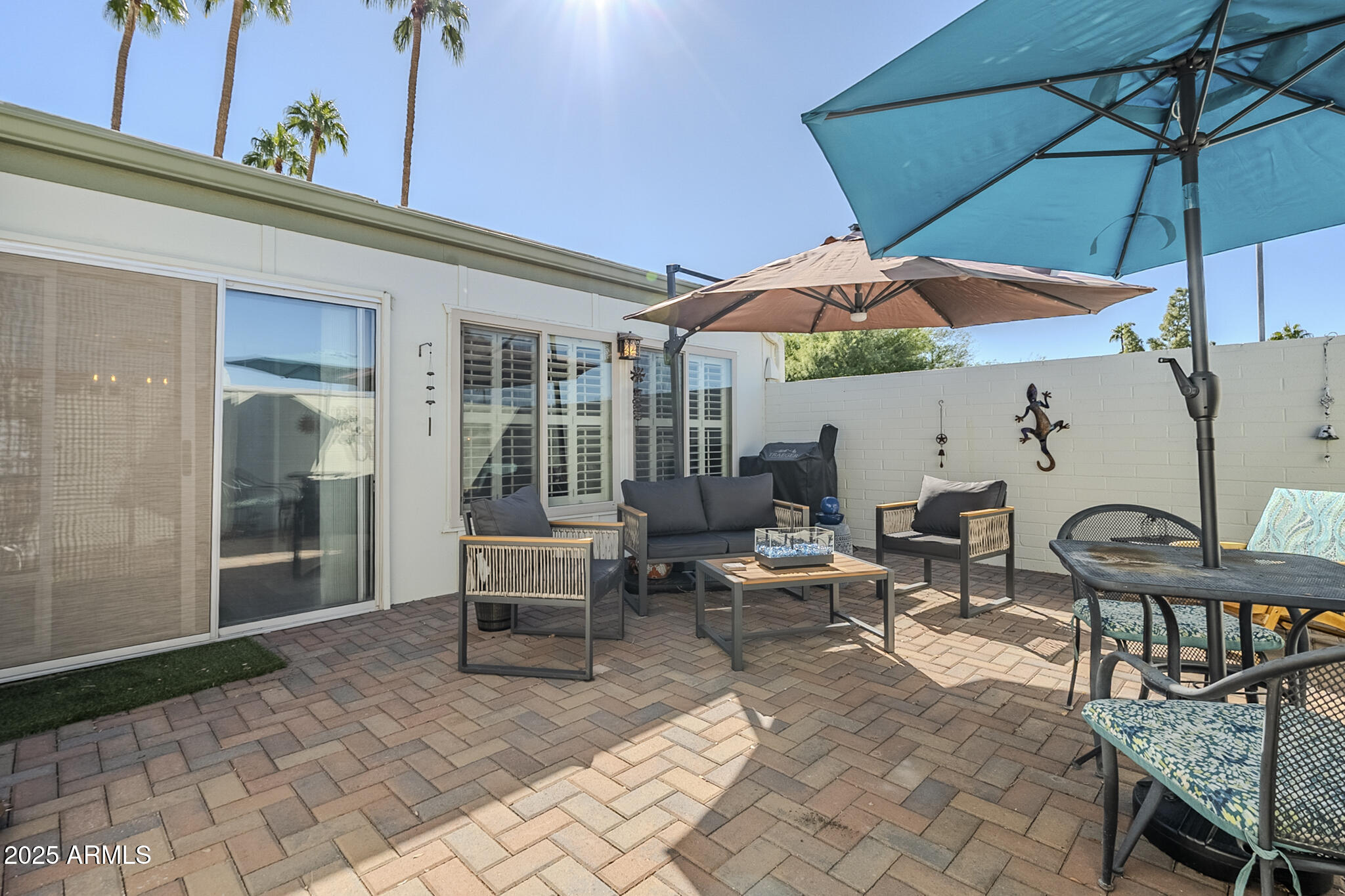 10010 West Royal Oak Road, Unit R Sun City, AZ 85351 - Photo 22 of 28 a view of a patio with a table and chairs under an umbrella