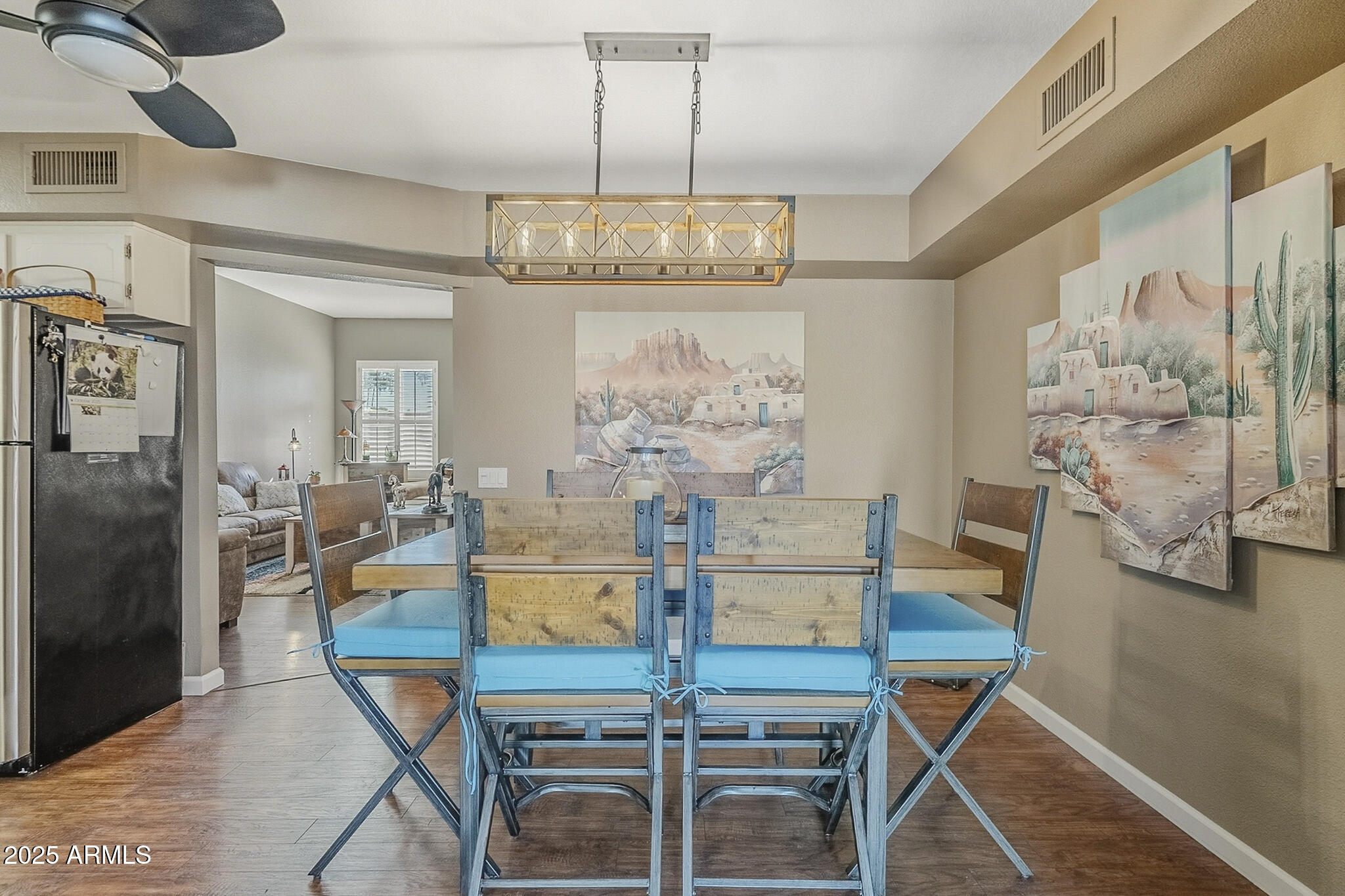 10010 West Royal Oak Road, Unit R Sun City, AZ 85351 - Photo 3 of 28 a view of a dining room with furniture a chandelier and wooden floor