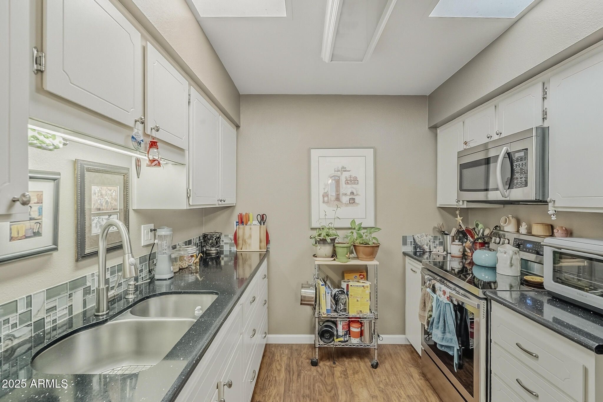 10010 West Royal Oak Road, Unit R Sun City, AZ 85351 - Photo 4 of 28 a kitchen with sink cabinets and window
