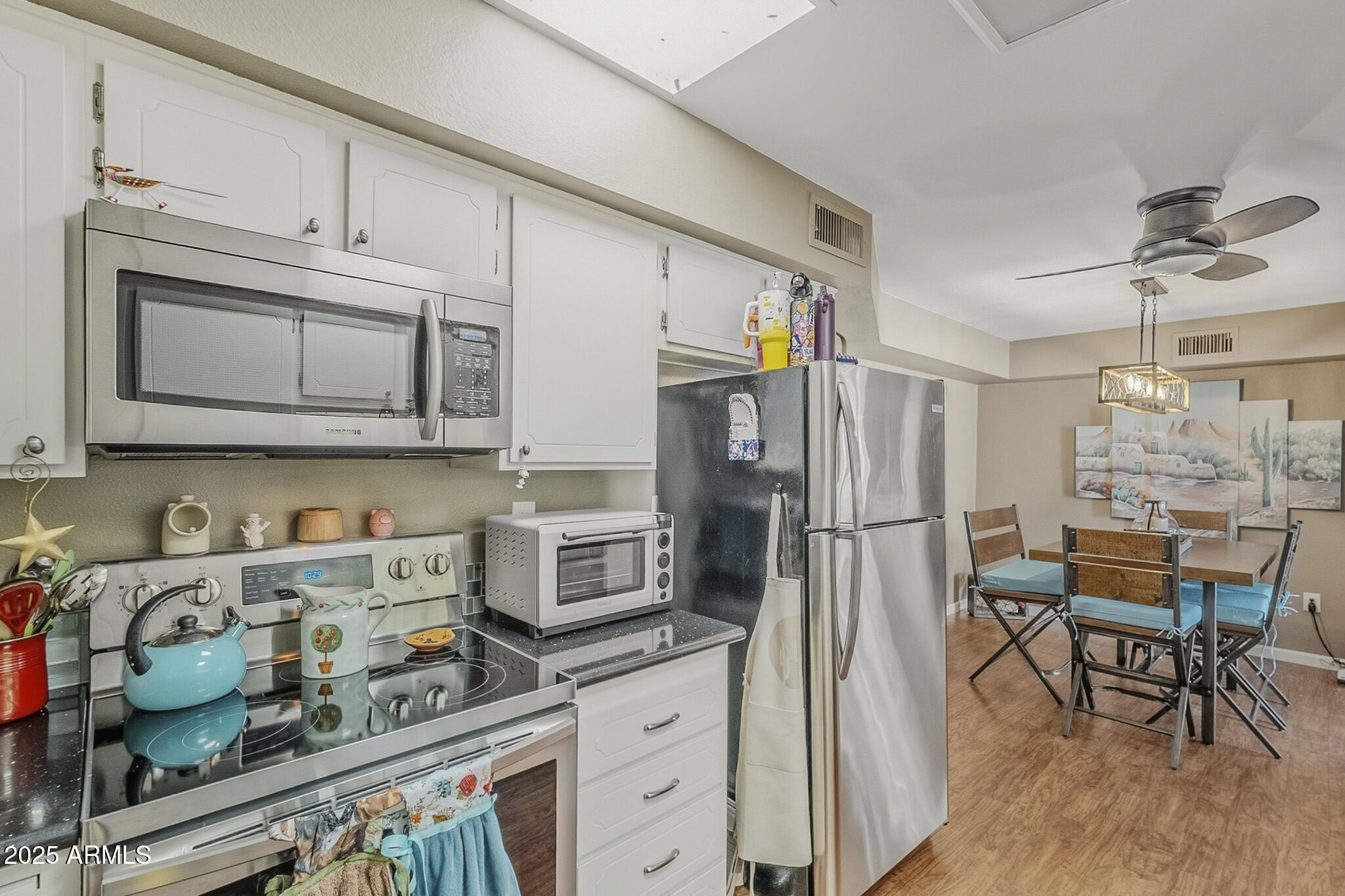 10010 West Royal Oak Road, Unit R Sun City, AZ 85351 - Photo 10 of 28 a kitchen with stainless steel appliances granite countertop a refrigerator and microwave