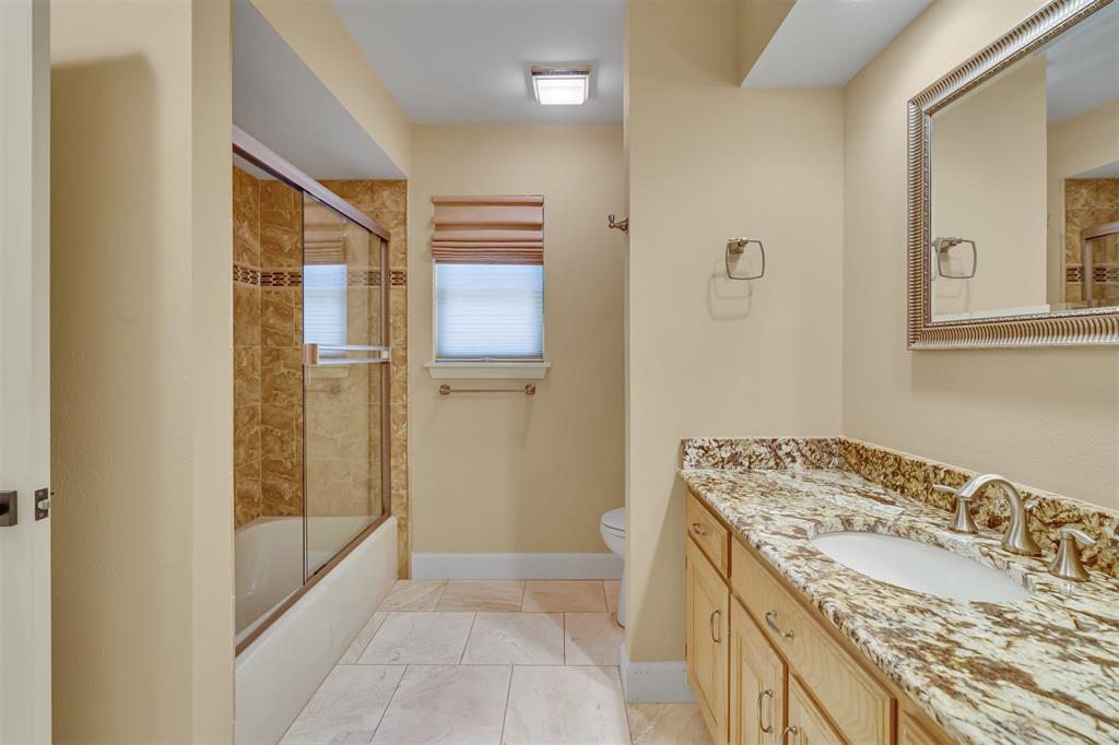 7019 Spring Valley Road Dallas, TX 75254 - Photo 14 of 19 a bathroom with a granite countertop sink a mirror and shower