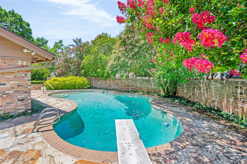 7019 Spring Valley Road Dallas, TX 75254 - Photo 18 of 19 a view of a backyard with plants and brick wall
