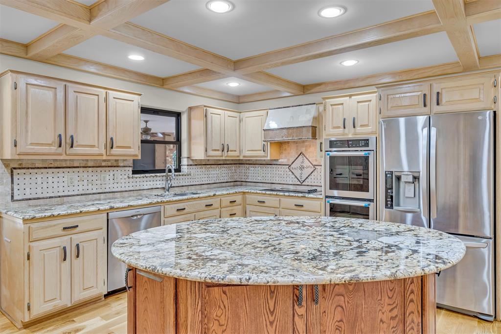 7019 Spring Valley Road Dallas, TX 75254 - Photo 3 of 19 a kitchen with kitchen island granite countertop a wooden cabinets counter top space and stainless steel appliances