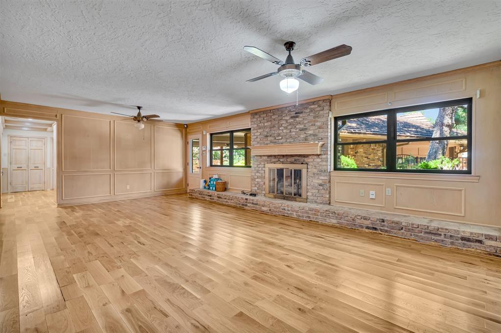 7019 Spring Valley Road Dallas, TX 75254 - Photo 4 of 19 a view of a livingroom with a fireplace a ceiling fan and windows