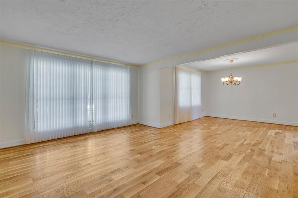7019 Spring Valley Road Dallas, TX 75254 - Photo 7 of 19 a view of an empty room with wooden floor and a window