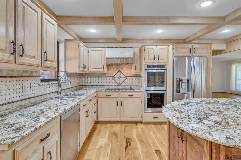 7019 Spring Valley Road Dallas, TX 75254 - Photo 8 of 19 a kitchen with stainless steel appliances granite countertop a stove sink and cabinets
