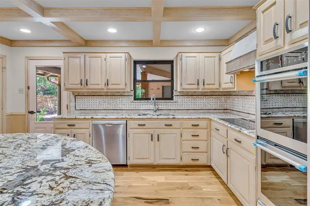 a large kitchen with granite countertop a sink stainless steel appliances and cabinets