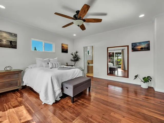 a spacious bedroom with a bed and a potted plant