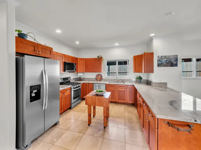 a large kitchen with granite countertop a large counter top stainless steel appliances and cabinets