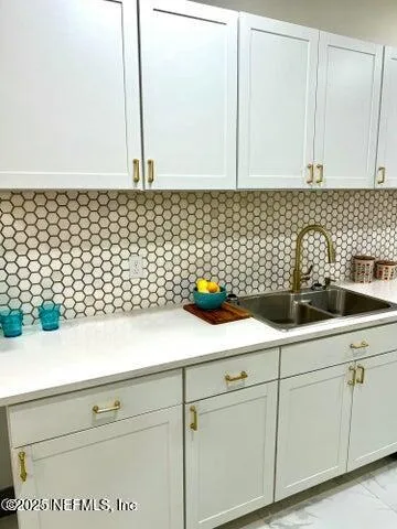 a sink with white cabinets
