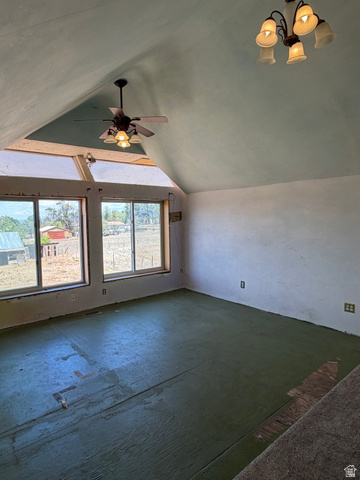 255 E Centre Spring City, UT 84662 - Photo 21 of 34 Attic room featuring a sloped ceiling, two windows, a ceiling fan with integrated lighting, and an additional chandelier fixture