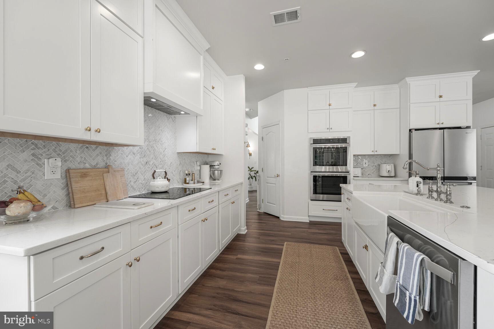 2604 Tree View Way Fort Washington, MD 20744 - Photo 13 of 50 a large kitchen with a large counter top a sink stainless steel appliances and cabinets