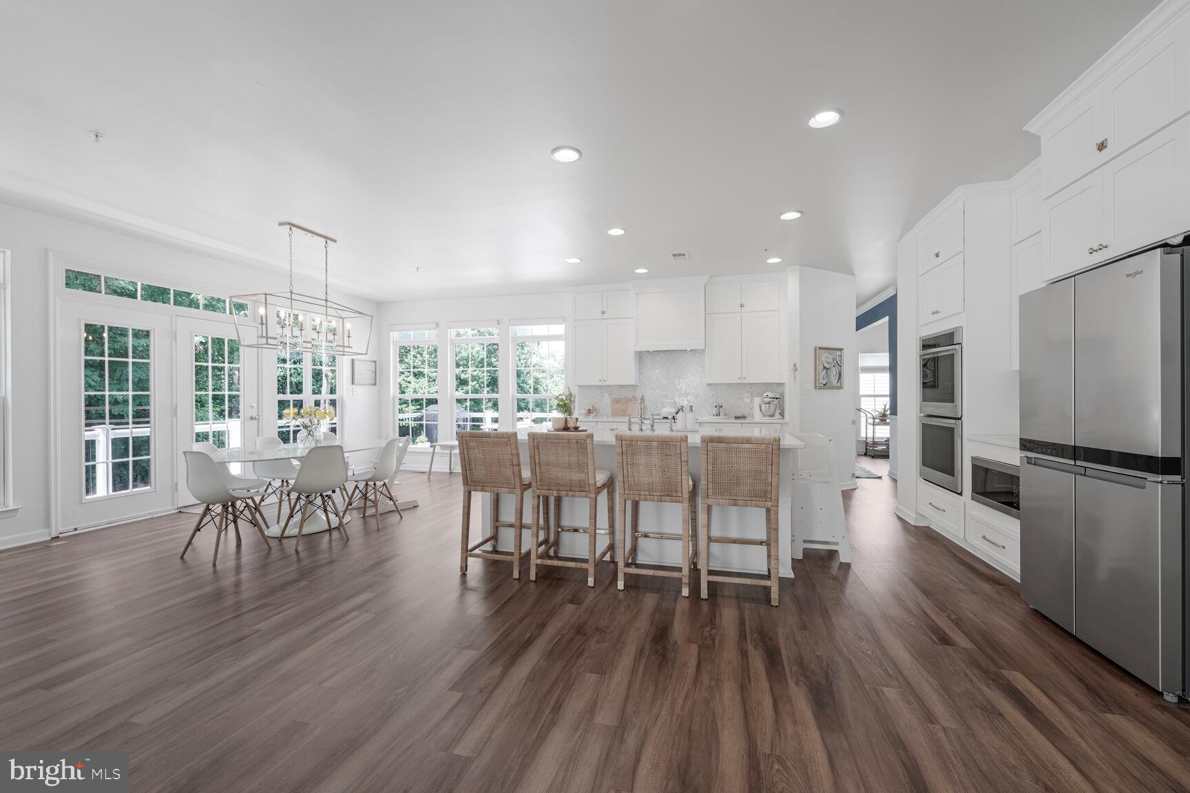 2604 Tree View Way Fort Washington, MD 20744 - Photo 14 of 50 a kitchen with a dining table chairs refrigerator and cabinets
