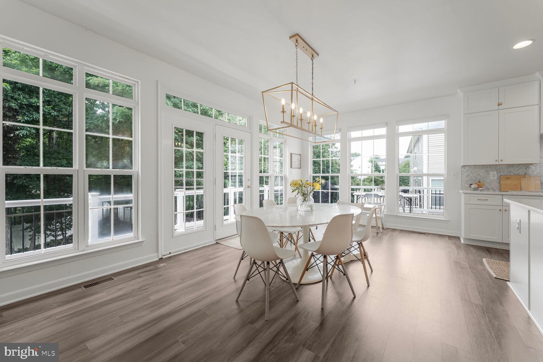 2604 Tree View Way Fort Washington, MD 20744 - Photo 17 of 50 a dining room with wooden floor a chandelier a wooden table and chairs