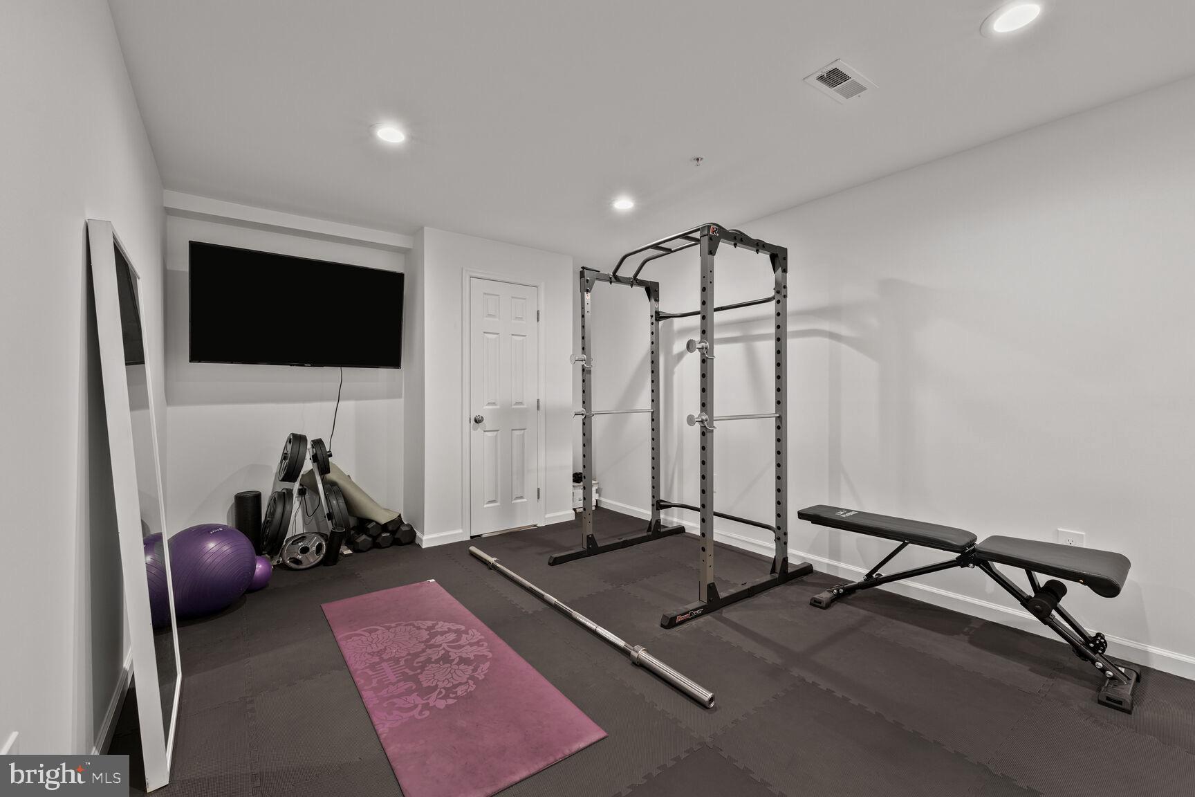 2604 Tree View Way Fort Washington, MD 20744 - Photo 41 of 50 a living room with gym equipment and a flat screen tv
