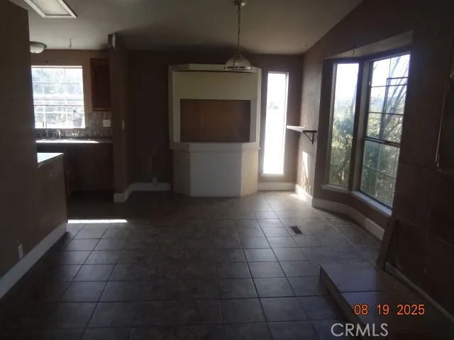 a view of a refrigerator in an empty room and window