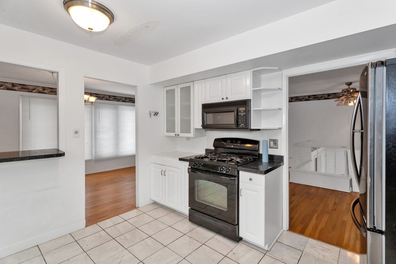 1900 Chippendale Road Hoffman Estates, IL 60169 - Photo 18 of 37 a kitchen with white cabinets and stainless steel appliances
