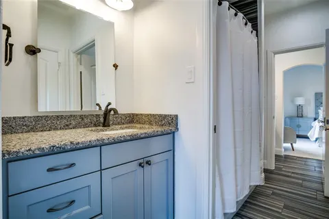 a bathroom with a granite countertop sink and a mirror