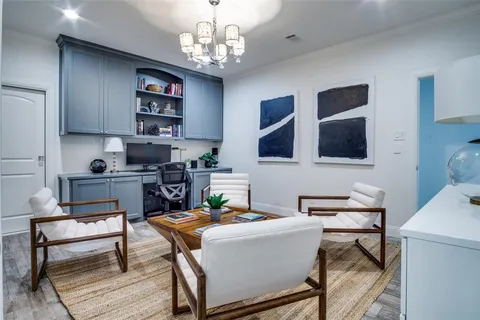 a work room with furniture wooden floor and a chandelier