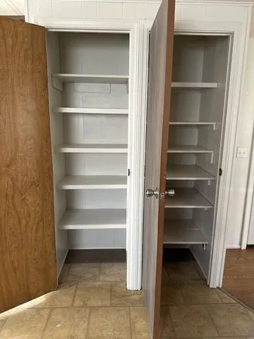 a view of walk in closet with empty racks