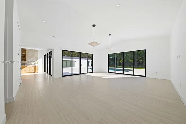 a view of an empty room with a window and fireplace