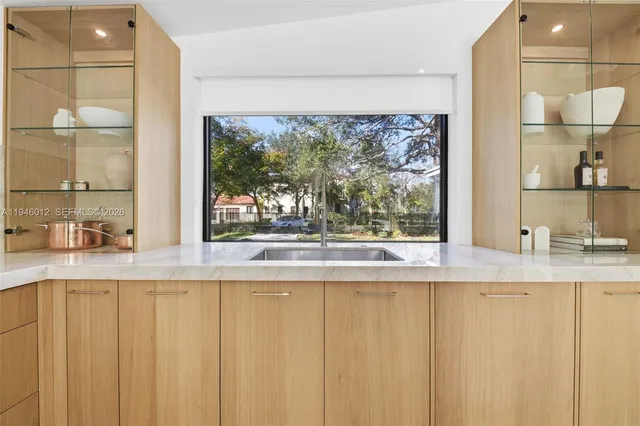 a view of a kitchen with a sink and a large window with kitchen view