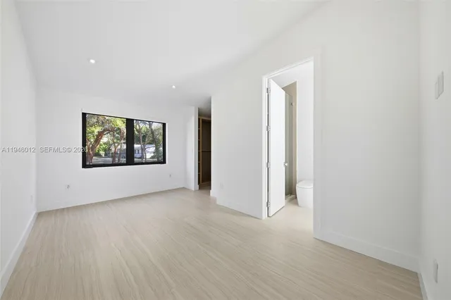 an empty room with wooden floor and cabinet