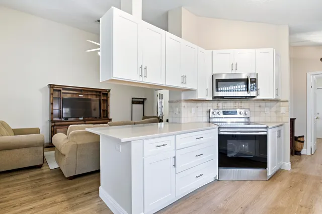 a kitchen with stainless steel appliances a stove a sink and a microwave