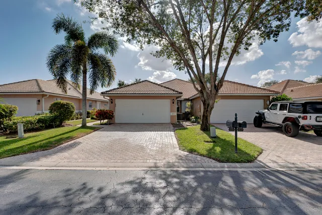 a front view of a house with garden and parking