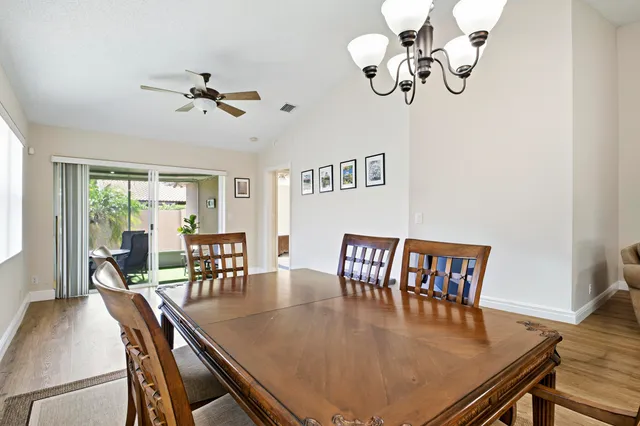 a view of a dining room and livingroom with furniture wooden floor a chandelier