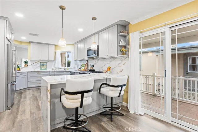 a kitchen with kitchen island a dining table chairs and white cabinets