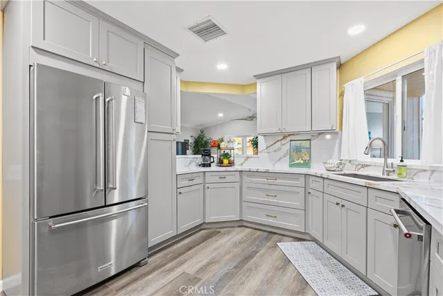 a kitchen with white cabinets and white stainless steel appliances