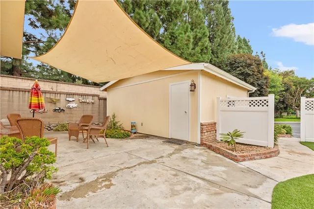 a view of a patio with table and chairs with wooden fence and plants