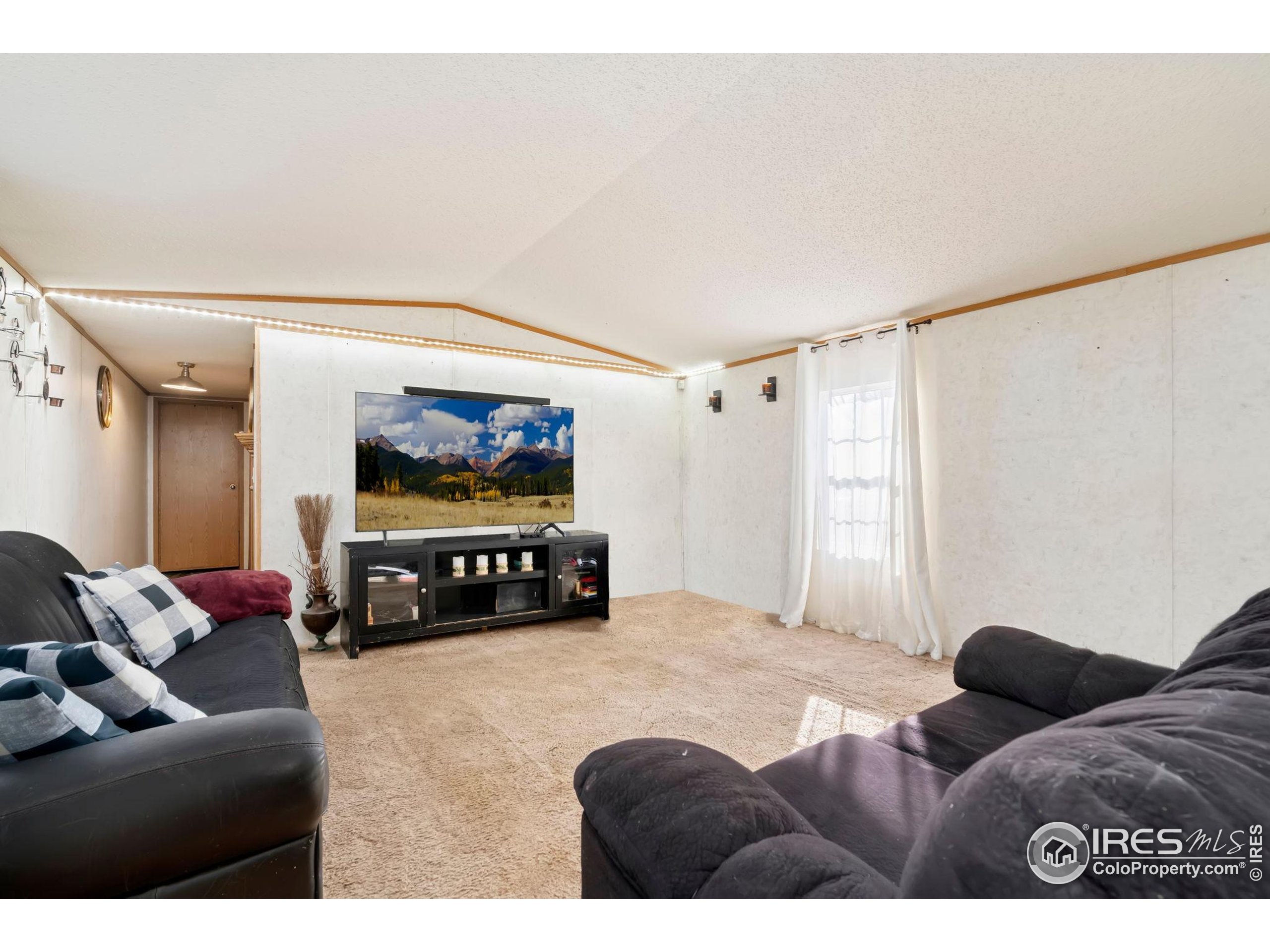 2500 East Harmony Road, Unit 166 Fort Collins, CO 80528 - Photo 12 of 24 a living room with furniture and a flat screen tv
