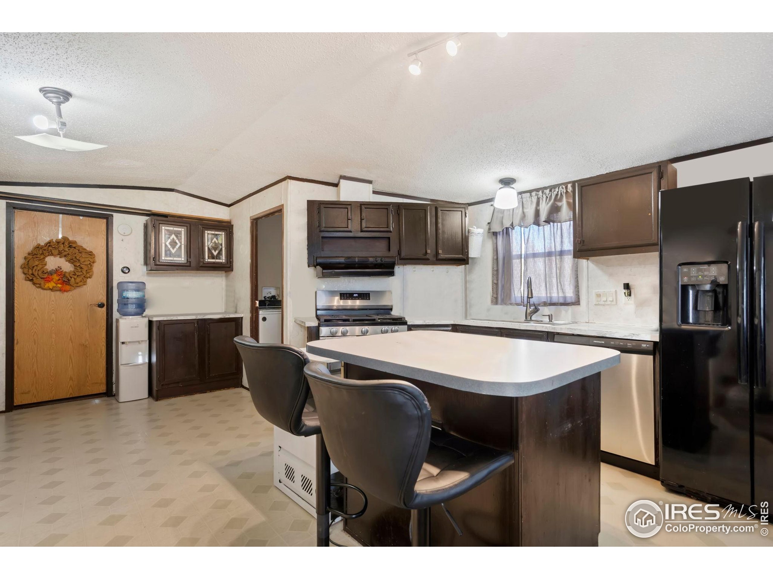 2500 East Harmony Road, Unit 166 Fort Collins, CO 80528 - Photo 7 of 24 a kitchen with stainless steel appliances a sink a stove a refrigerator cabinets and a dining table