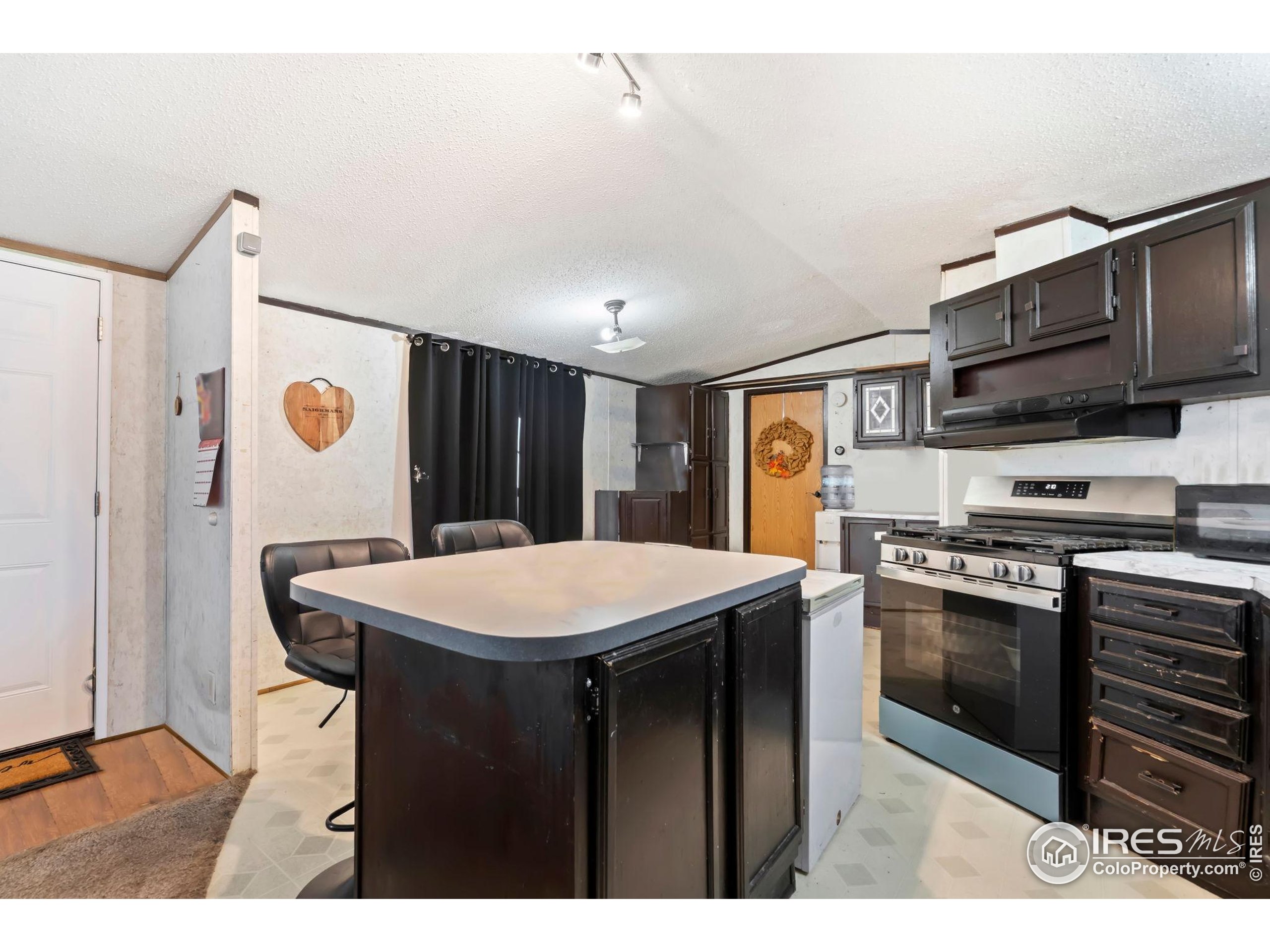 2500 East Harmony Road, Unit 166 Fort Collins, CO 80528 - Photo 8 of 24 a kitchen with stainless steel appliances granite countertop a stove a sink dishwasher and a refrigerator with wooden floor
