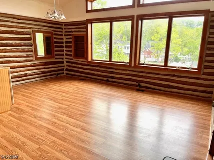 a view of a room with wooden floor and windows