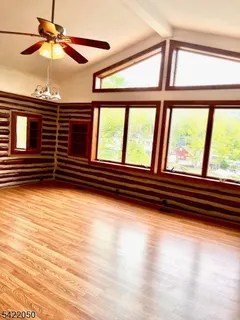 a view of room with wooden floor and windows