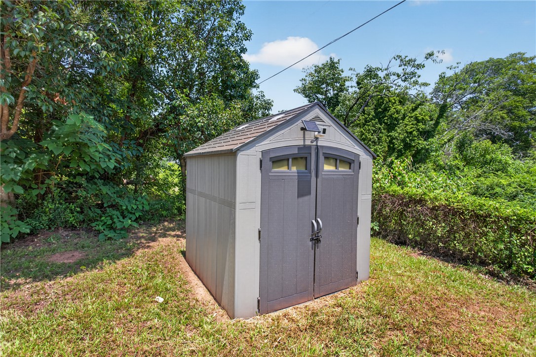 115 Pelfrey Street Seneca, SC 29672 - Photo 37 of 46 A well-maintained outdoor storage shed provides ample utility space amidst lush greenery.