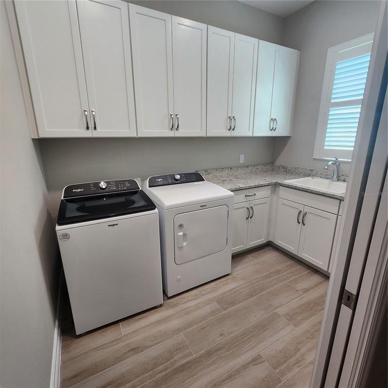 512 Blue Shell Loop Sarasota, FL 34240 - Photo 40 of 44 a kitchen with white cabinets and white appliances