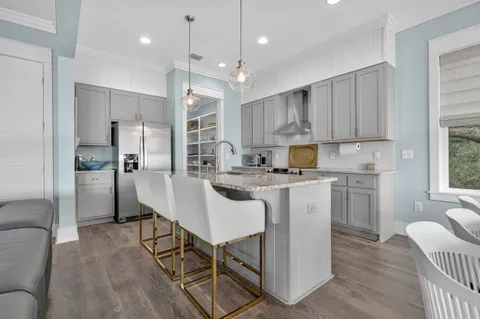 a bedroom with a bed a chair and a lamp on the dresser
