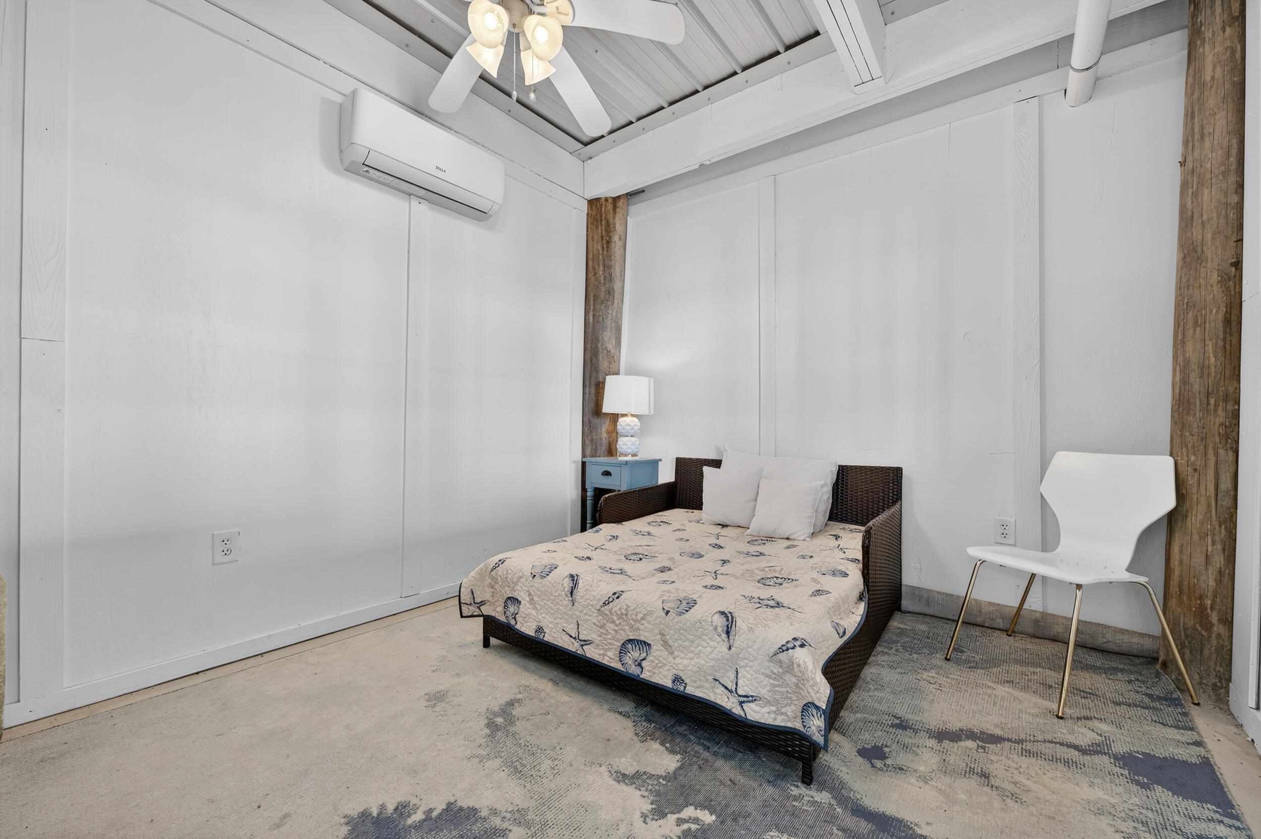 2975 Holley Point Road Navarre, FL 32566 - Photo 75 of 101 a bedroom with a bed a chair and a lamp on the dresser