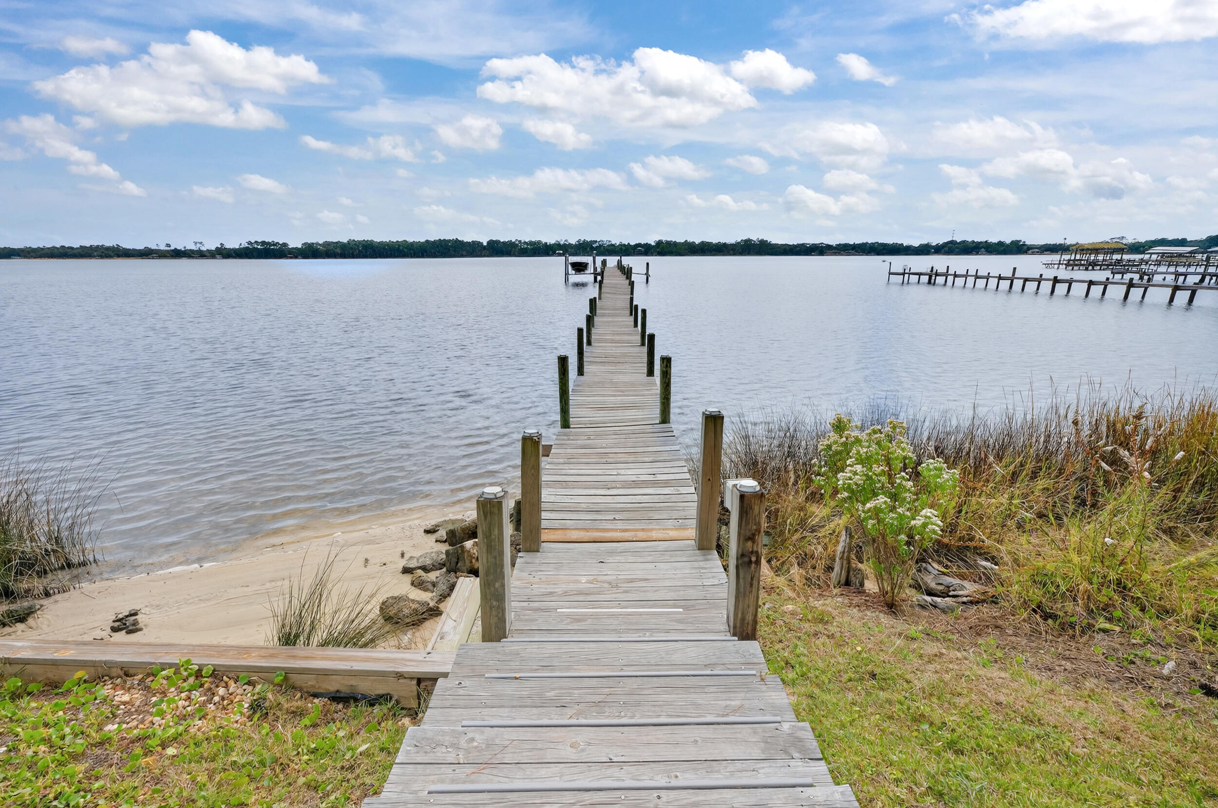 2975 Holley Point Road Navarre, FL 32566 - Photo 80 of 101 a view of a lake with a bench in the background