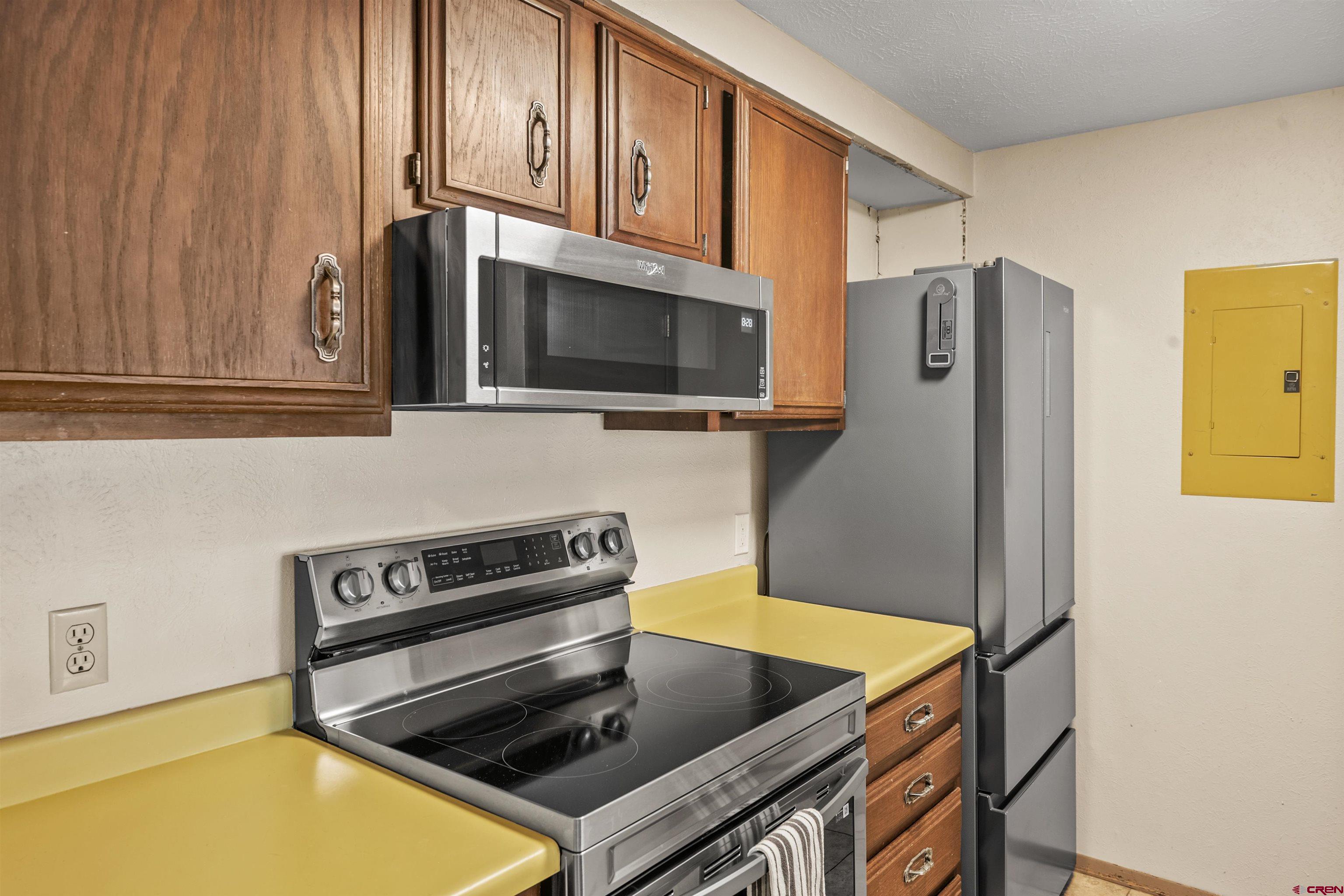 651 Gothic Road, Unit 306 Crested Butte, CO 81225 - Photo 14 of 24 a kitchen with stainless steel appliances granite countertop a stove a microwave and a refrigerator