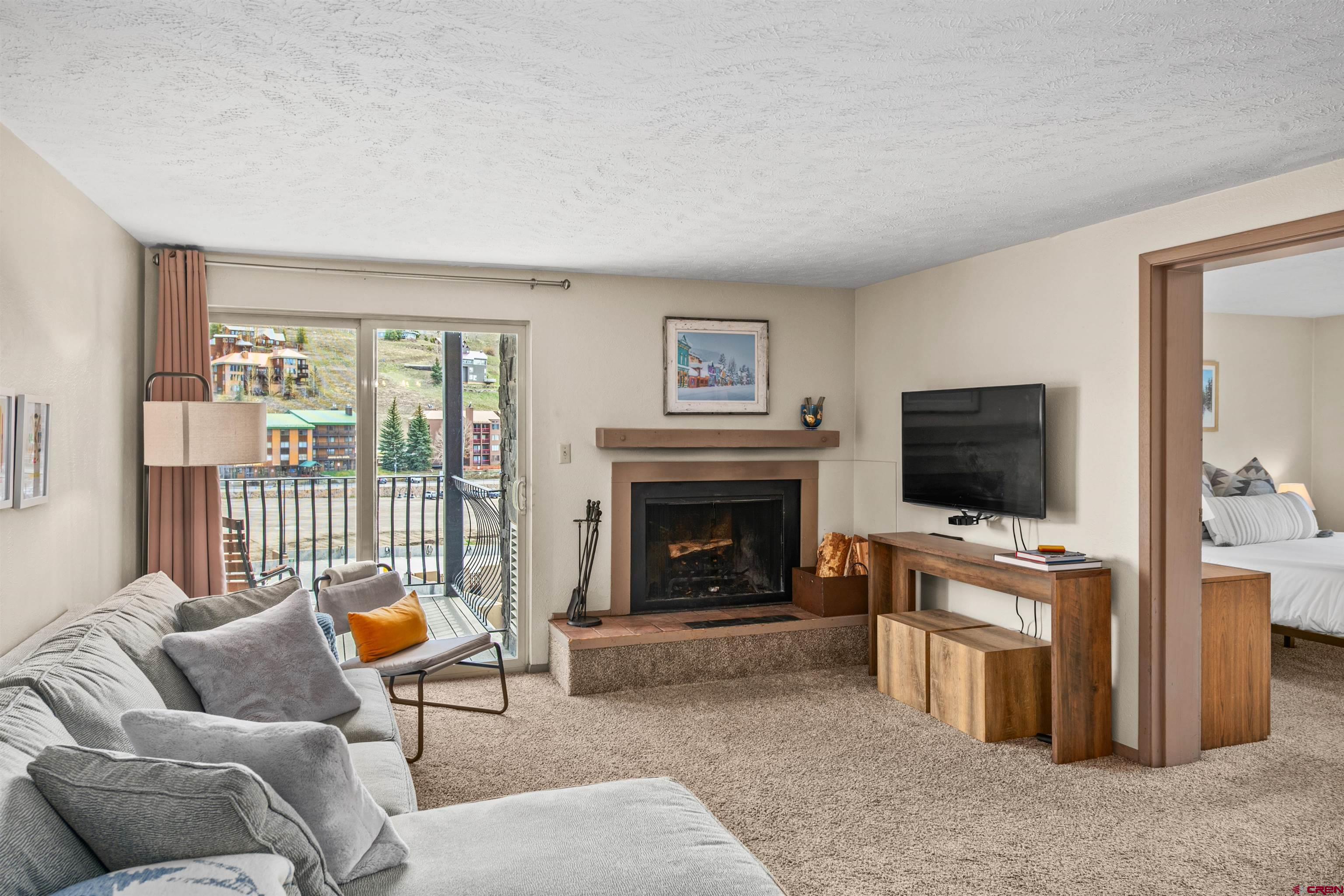 651 Gothic Road, Unit 306 Crested Butte, CO 81225 - Photo 5 of 24 a living room with furniture and a flat screen tv