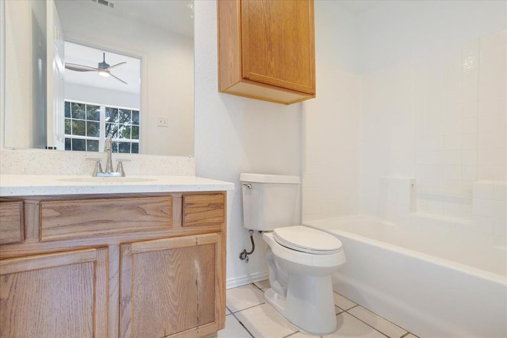 700 East 6th Street Bonham, TX 75418 - Photo 23 of 28 a bathroom with a sink toilet vanity and tub