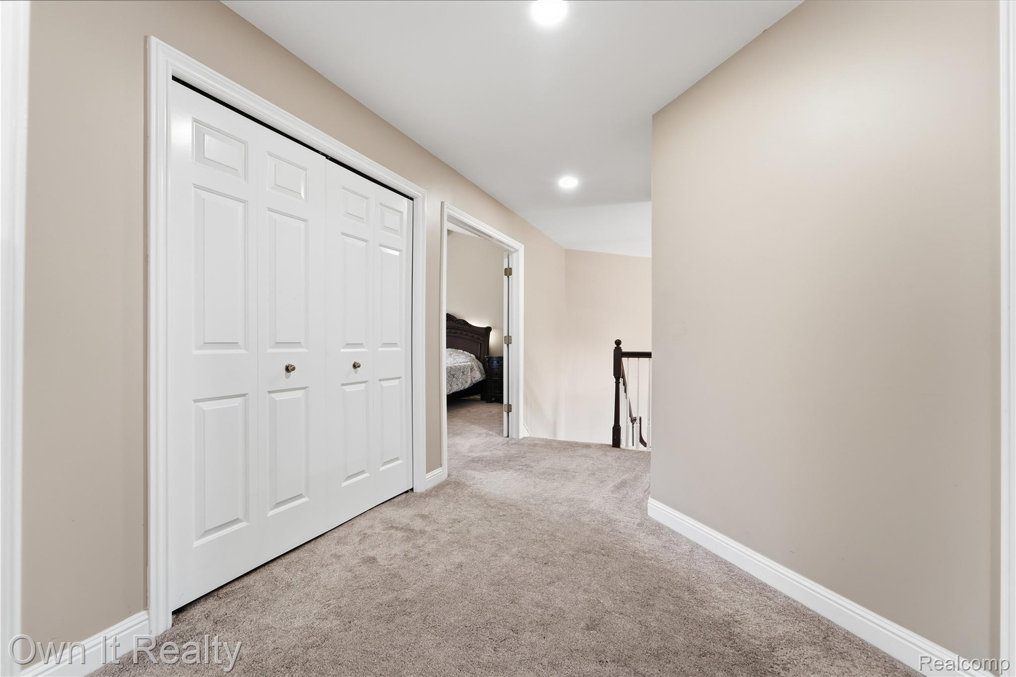 48280 Gladstone Road Canton, MI 48188 - Photo 30 of 59 Hallway featuring plush carpet, recessed lighting, bi-fold closet doors with brass hardware, and neutral paint