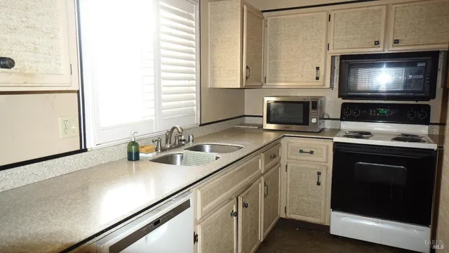 a kitchen with stainless steel appliances a stove microwave and sink