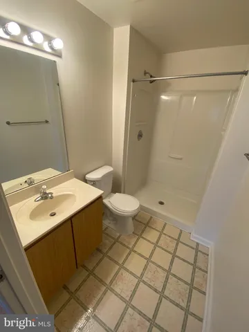 a bathroom with a sink a toilet a mirror and shower